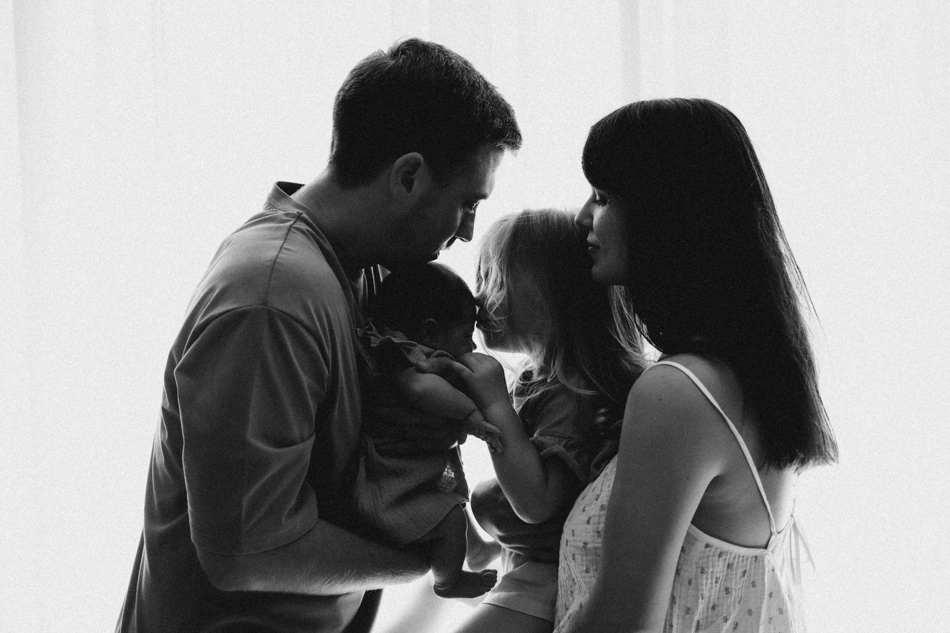A black and white photo of a family looking at each other